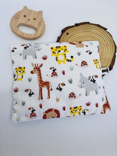 Brinquedo de madeira em forma de gato junto a almofada com padrão de animais da selva coloridos