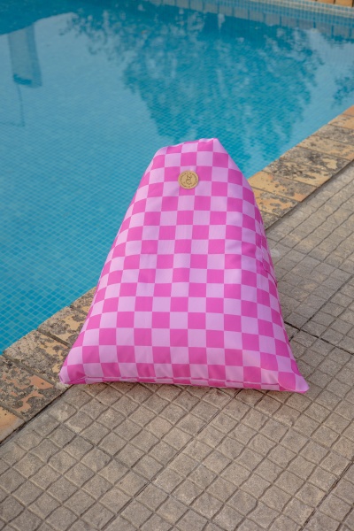 Pufe triangular xadrez rosa ao lado de piscina