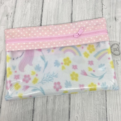Estojo transparente com fecho rosa e padrão colorido de flores e unicórnio