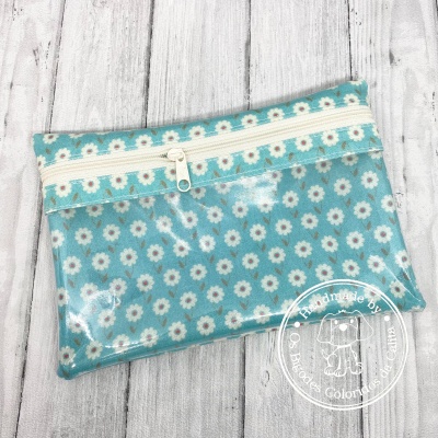Bolsa impermeável azul com padrão de margaridas e fecho branco