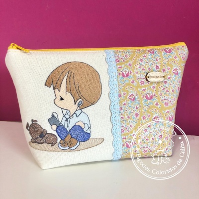 bolsa de mão com ilustração bordada de menino e cão e padrão floral amarelo e lilás