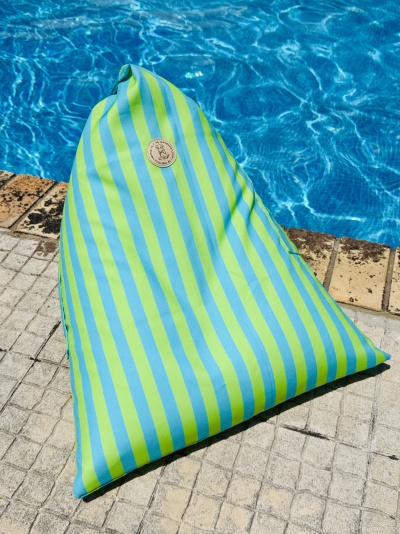 Pufe triangular azul e verde ao lado de piscina