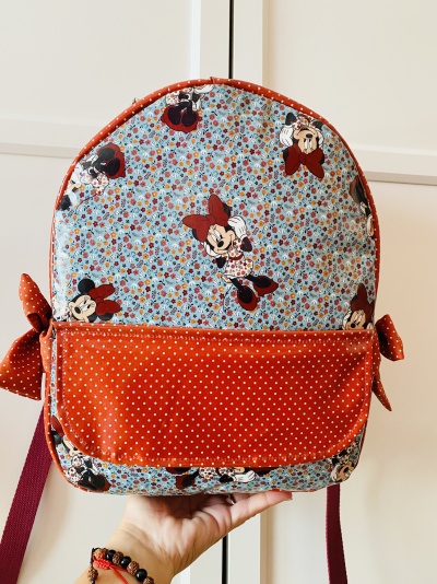 Mochila infantil com padrão Minnie Mouse em azul floral e bolso laranja com bolinhas