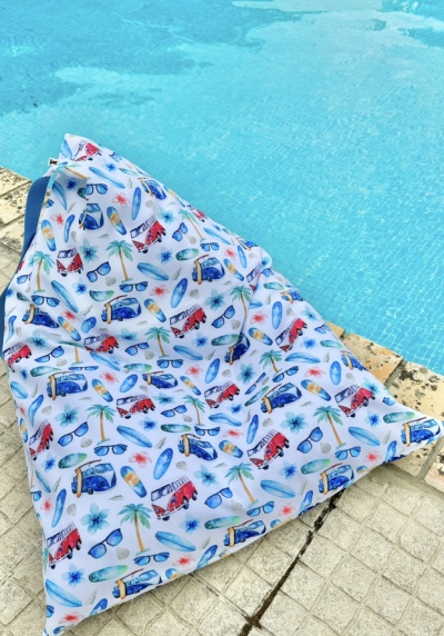 Puff triangular estampado com motivos de verão junto à piscina