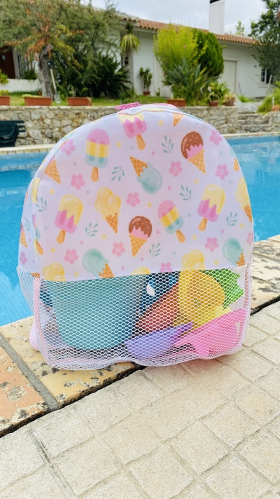 Mochila rosa com padrão de gelados junto à piscina