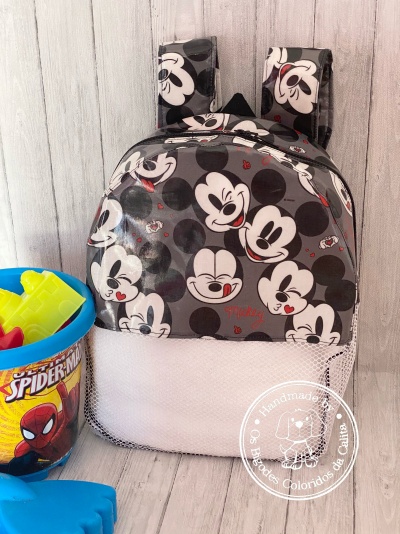 Mochila infantil Mickey Mouse preta, branca e cinza com balde de brinquedos coloridos ao lado