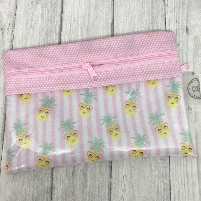 Estojo pequeno transparente com fecho rosa e padrão de abacaxis sorridentes