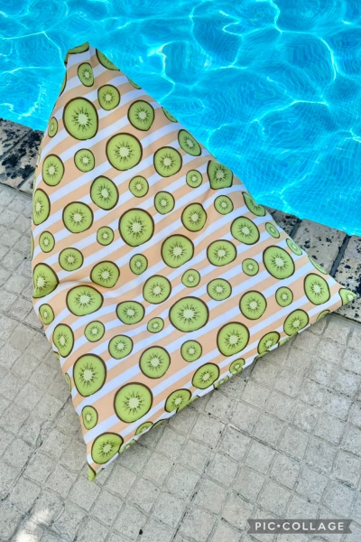 Almofada triangular com estampa de kiwis junto a piscina