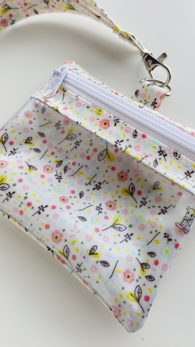 Bolsa pequena rígida com padrão floral colorido e fecho branco