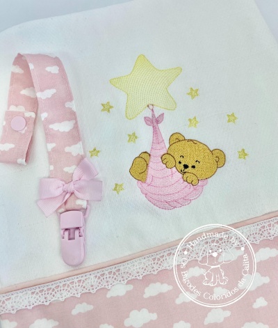 Fralda e prendedor de chupeta rosa com padrão de nuvens e bordado de urso