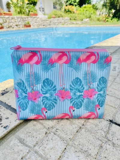 Bolsa estampada com flamingos e folhas junto à piscina