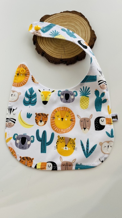 Babete branco com padrões de animais e plantas coloridas