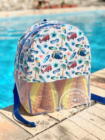 Mochila branca com padrão colorido de praia junto à piscina