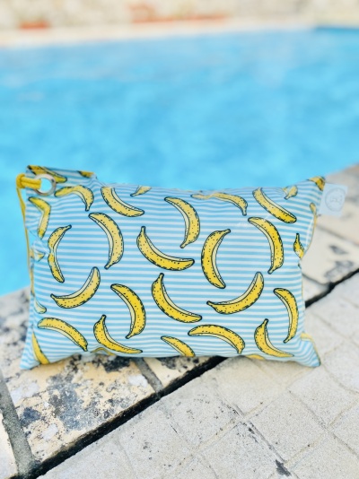 Bolsa pequena com padrão de bananas junto a uma piscina