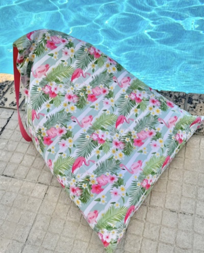 Saco impermeável colorido com padrão de flamingos e flores junto a piscina