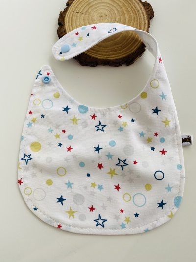 Babete branco com estrelas e círculos coloridos e fecho azul