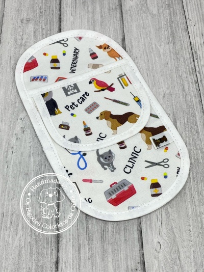 Tecido branco estampado com motivos veterinários e animais sobre madeira clara