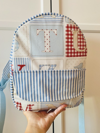 Mochila com padrão de letras e números e bolso riscado azul e branco