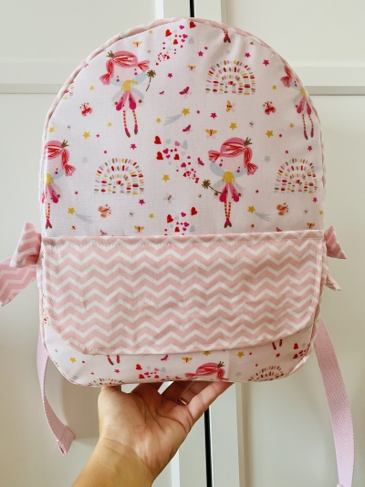 Mochila infantil rosa com padrão de fadas e bolso frontal zigzag rosa