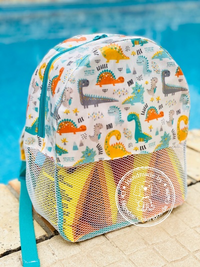 Mochila infantil branca com estampado de dinossauros coloridos e bolso de rede