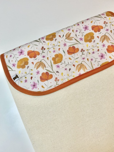Capa de tecido com padrão floral e acabamento laranja