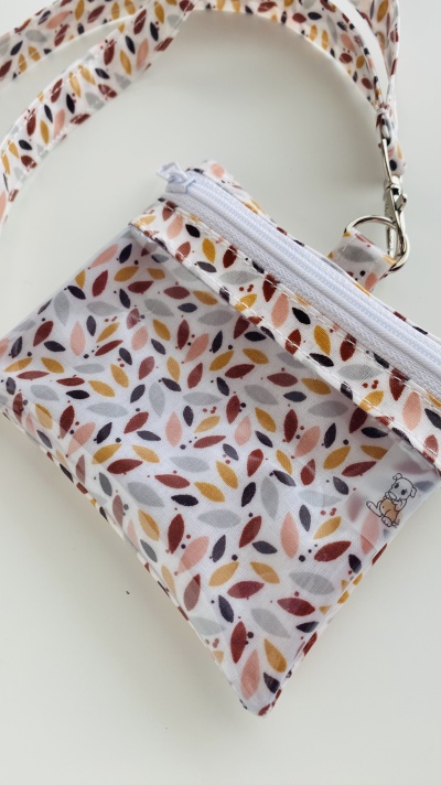 Bolsa pequena de tecido com padrão de folhas coloridas e asa com mosquetão