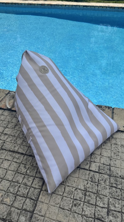 almofada riscas brancas e bege ao lado de piscina