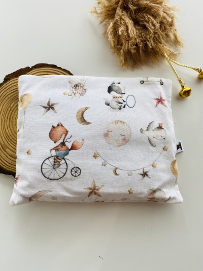 Almofada decorativa com desenho infantil de raposa, cão, lua e estrelas em cores suaves.