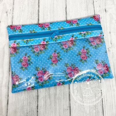 Bolsa azul claro com padrão de rosas cor-de-rosa e fecho de correr