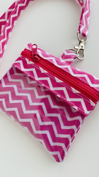 Carteira pequena cor-de-rosa e branco com padrão zig-zag e fecho de correr vermelho
