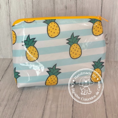 Bolsa pequena com padrão de abacaxis e fecho amarelo