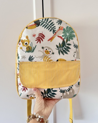 Mochila infantil com padrão de animais e bolso amarelo às riscas