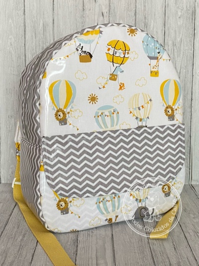 Mochila infantil com padrão colorido de balões de ar quente e animais com detalhes em zigzag cinza e branco