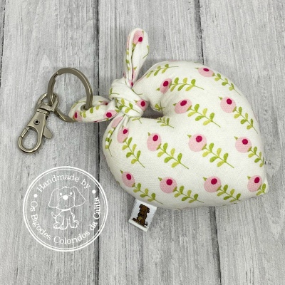 Porta-chaves em tecido branco com padrão floral rosa e verde em formato coração com argola metálica