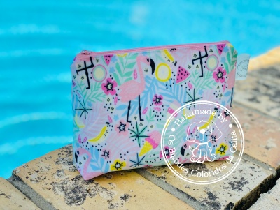 Bolsa pequena colorida com estampado de flamingos e frutas junto a piscina