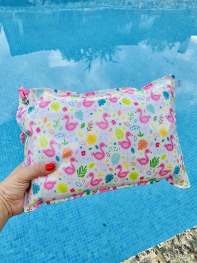 Bolsa colorida com padrão de flamingos, flores e folhas junto a piscina