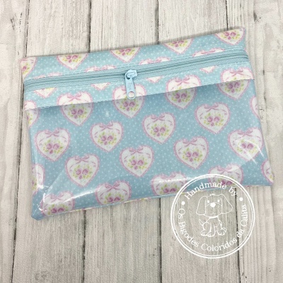 Bolsa azul claro com padrão de corações e fecho de correr