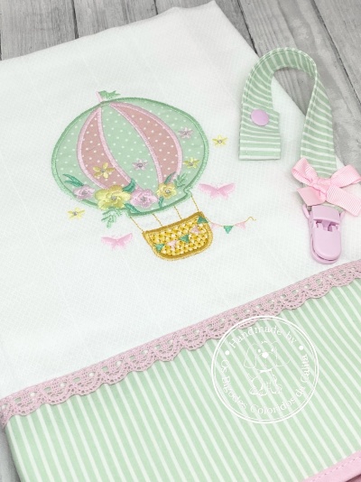 Toalha branca bordada com balão colorido e prendedor de chupeta rosa e verde