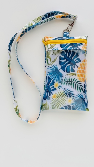 Bolsa pequena com padrão tropical e fecho amarelo
