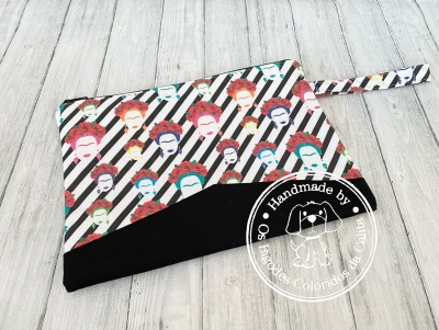 Necessaire colorida com padrões de rostos femininos e selo de artesanato
