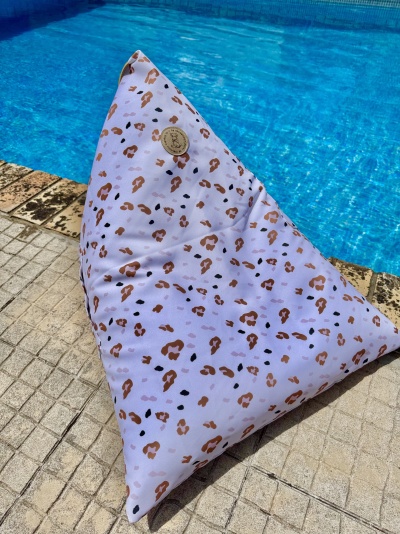 Pufe triangular com estampa animal junto a piscina