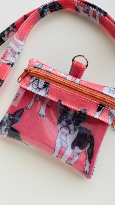 Bolsa pequena cor-de-rosa com padrão de cães e fecho de correr cor-de-laranja