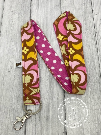 Cordão lanyard com padrões florais e de bolinhas, com argola e fecho metálico