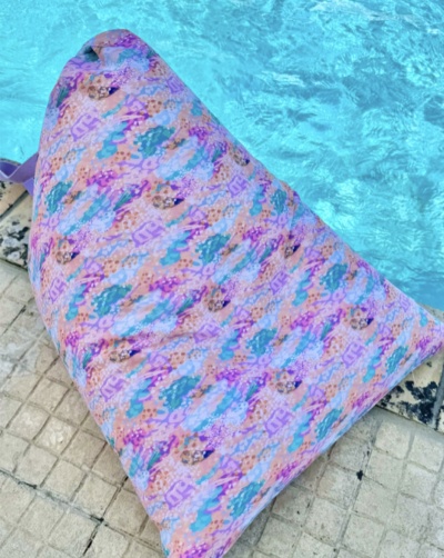 Almofada de encosto triangular colorida junto a piscina
