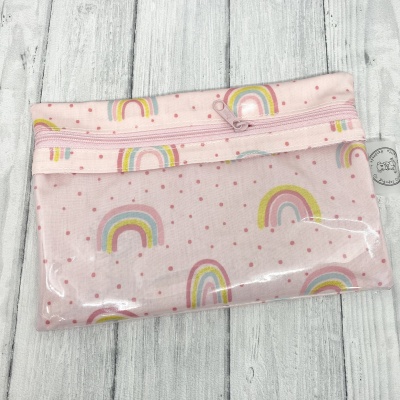 Estojo rosa com arco-íris e bolinhas, parte frontal transparente