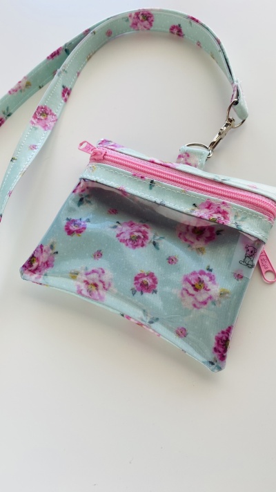 Bolsa pequena com padrão floral azul claro e rosa com fecho rosa