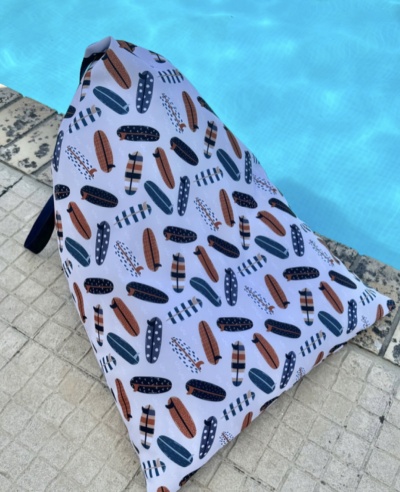 Mochila branca com padrão gráfico colorido ao lado de piscina