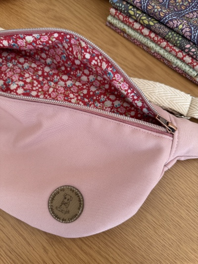 Bolsa de cinto rosa com interior floral e tecidos dobrados