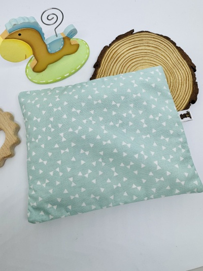 Almofada ou saco térmico azul claro com padrão de triângulos brancos, brinquedo de cavalo-marinho e suporte de madeira