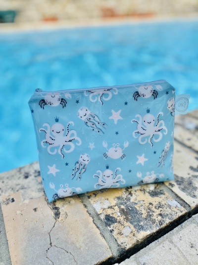 Bolsa azul claro com estampado marinho de polvos e caranguejos junto à piscina